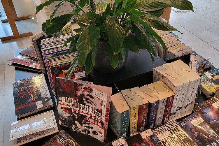 Picture of books on a table with a plant in the middle